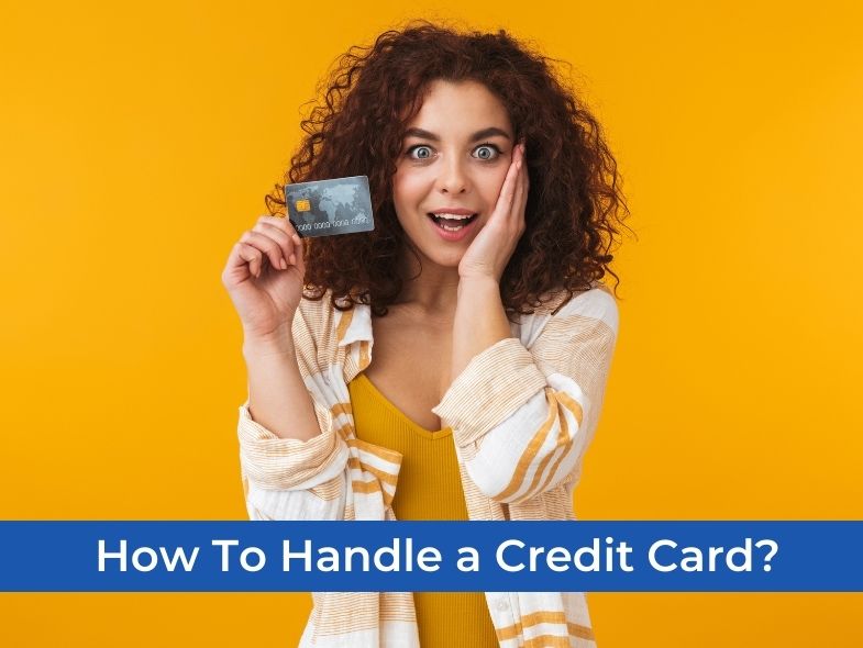 A girl with curly hair is delighted while holding a credit card in her left hand.